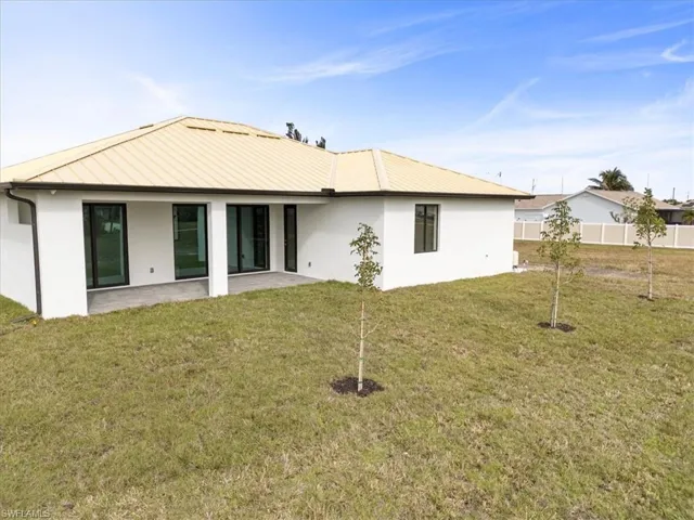 Back of property featuring a lawn and a patio