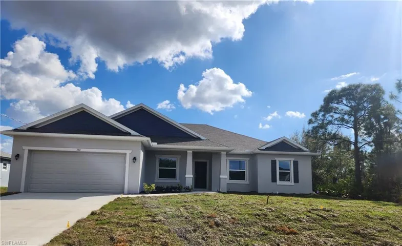 Ranch-style house featuring a front lawn, a garage, stucco siding, and concrete driveway