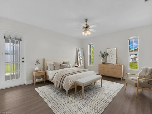 Spacious room featuring wood-finish flooring, light neutral wall paint, and a ceiling fan with integrated lighting