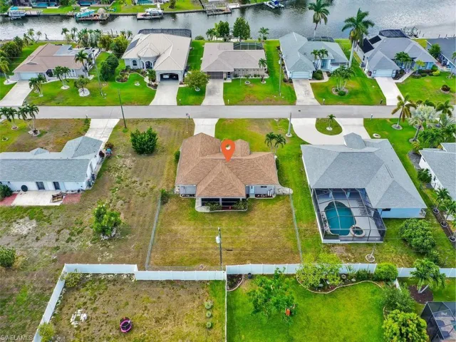Aerial property overview showcasing a residential structure with a screened pool enclosure