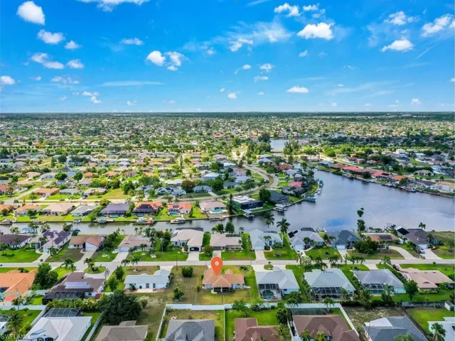 Expansive aerial perspective showcasing a residential area with numerous single-story homes, many featuring private screened enclosures