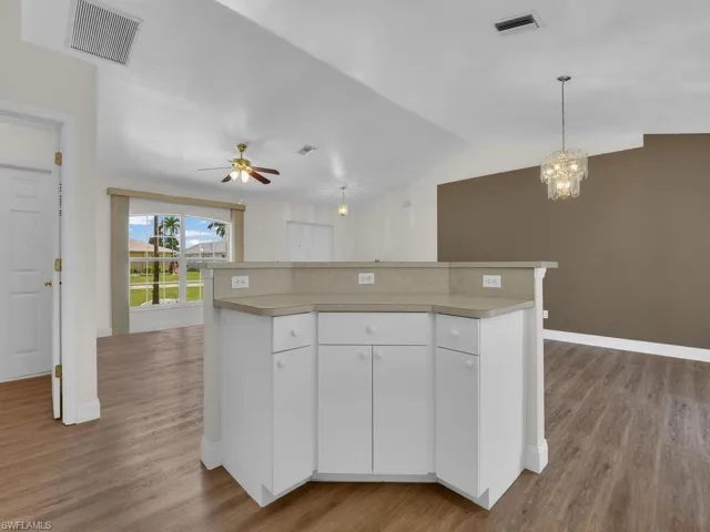 Kitchen island with a light-toned countertop and white cabinetry