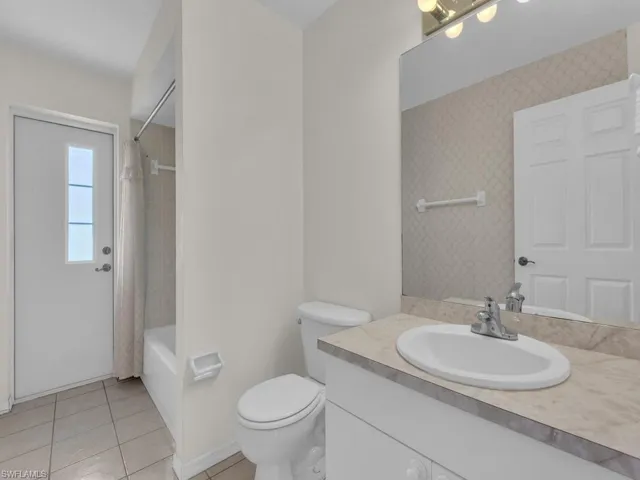 Bathroom with a single vanity, integrated sink, and patterned countertop