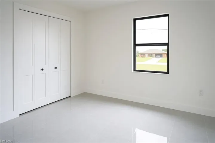 Unfurnished bedroom with light tile patterned flooring and a closet
