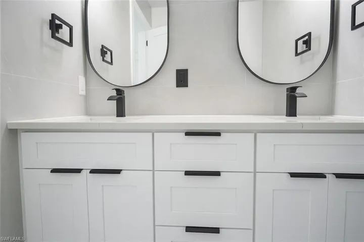 Bathroom featuring double vanity and decorative backsplash
