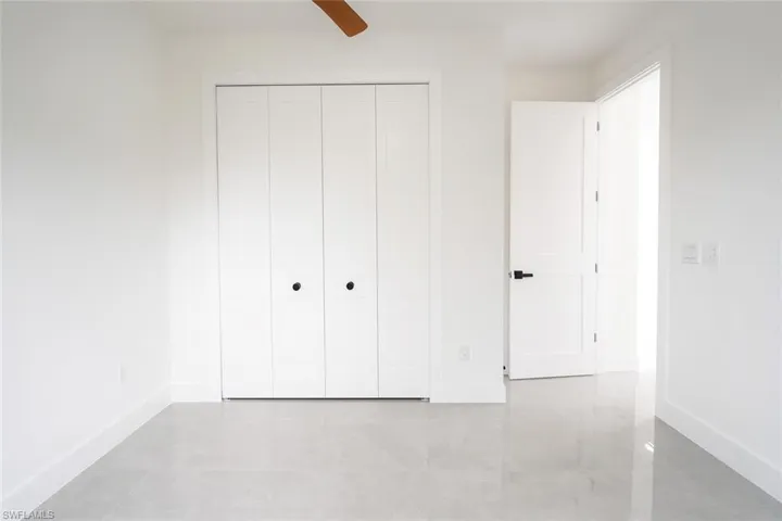 Unfurnished bedroom featuring tile patterned floors, ceiling fan, and a closet