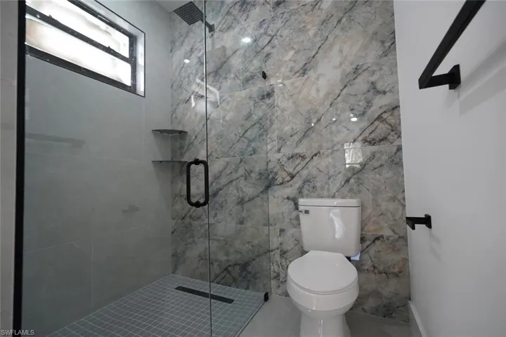 Bathroom featuring a shower stall and toilet