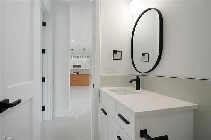 Half bathroom with vanity and light tile patterned floors