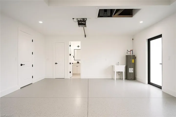 Garage featuring recessed lighting, electric water heater, and a garage door opener