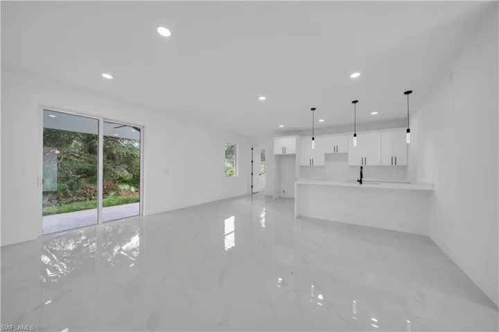 Unfurnished living room featuring recessed lighting and light marble finish floors
