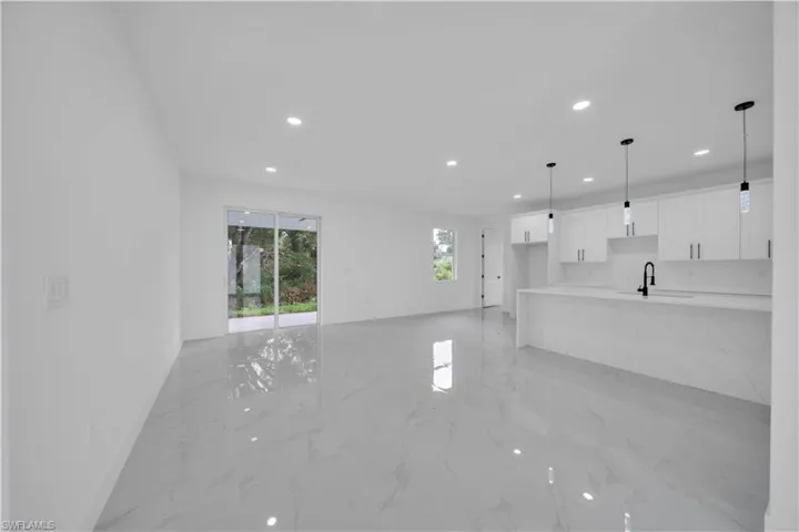 Unfurnished living room featuring light marble finish floors and recessed lighting