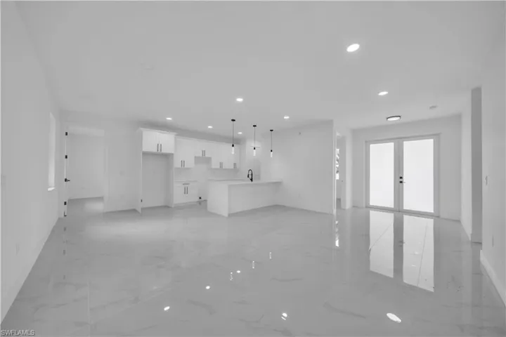 Unfurnished living room featuring recessed lighting, french doors, and light marble finish floors