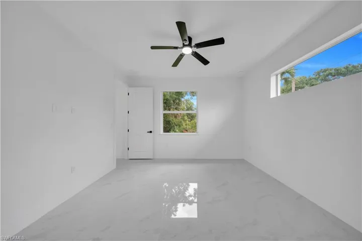 Spare room with light marble finish floors and a ceiling fan