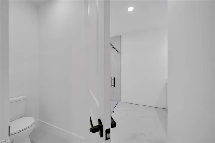 Bathroom featuring light marble finish floors, a marble finish shower, and recessed lighting