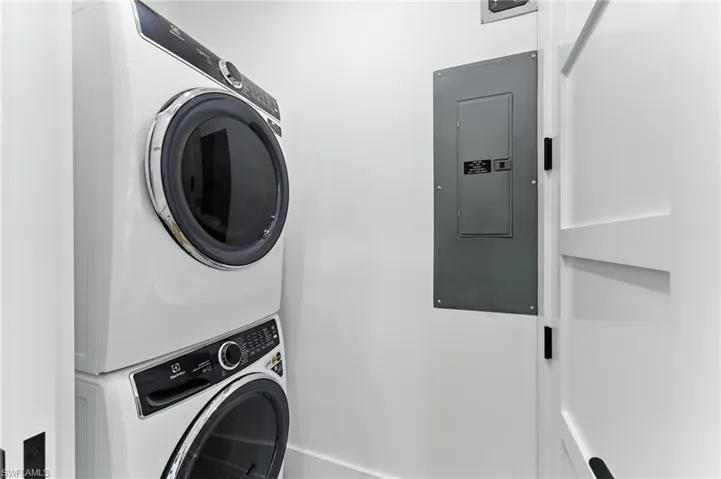 Laundry area with stacked washer / drying machine and electric panel