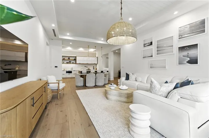 Living room featuring recessed lighting, light wood-style flooring, and a tray ceiling