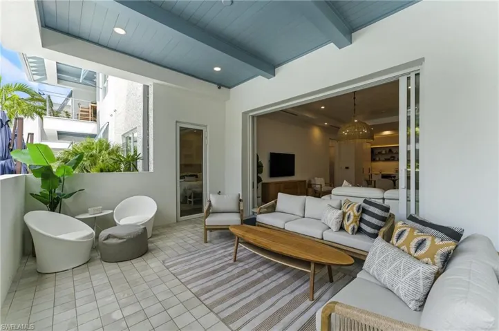 Tiled living area featuring a wooden ceiling with exposed beams and recessed lighting - IMPACT SLIDERS AND WINDOWS - DOOR TO PRIMARY OFF PATIO - SOUTHERN EXPOSURE