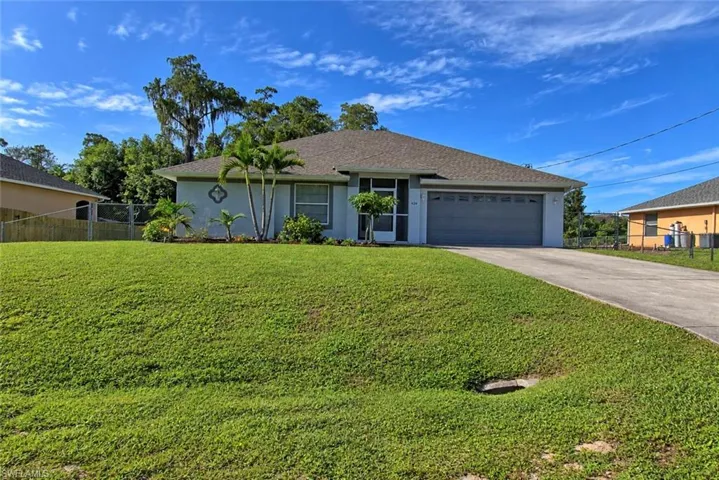 Single-story residence with a gray shingle roof, attached two-car garage, and a screened front entry