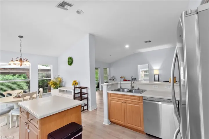 Kitchen featuring wood-finish flooring, recessed lighting, wood cabinetry, a double basin stainless steel sink, and stainless steel appliances