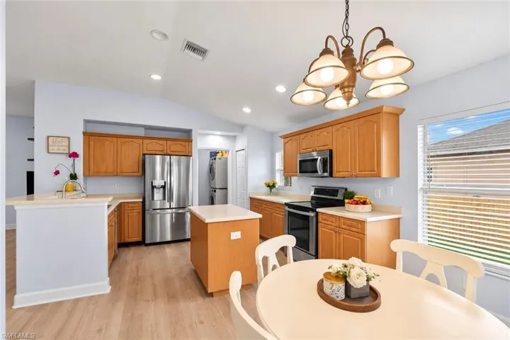 Kitchen featuring wood-finish cabinetry, stainless steel appliances, a center island, and wood-finish flooring