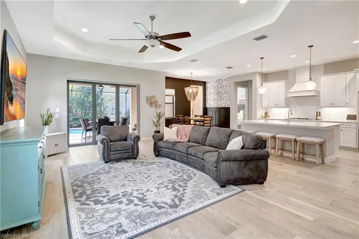 Open concept living area with ceiling fan, recessed lighting, light wood-style tile flooring throughout