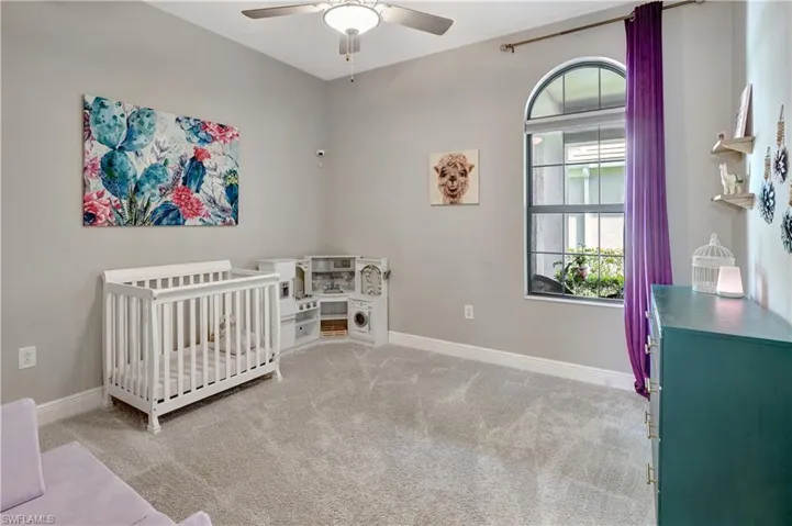 Third bedroom featuring carpet flooring, a ceiling fan, and baseboards