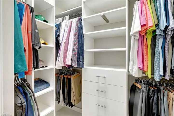 View of spacious closet with custom built in shelving