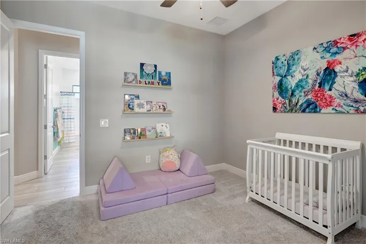 Third bedroom featuring carpet flooring, a ceiling fan, and baseboards