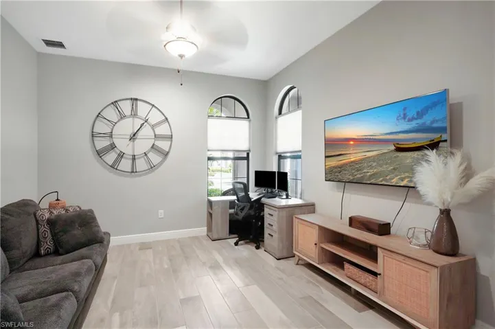 Spacious den adjacent to living room featuring French doors