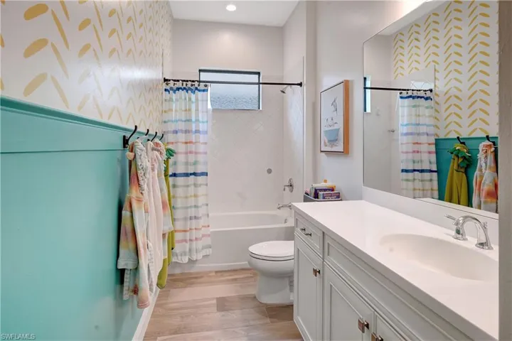 Full bathroom featuring toilet, shower / bath combo with shower curtain, and vanity