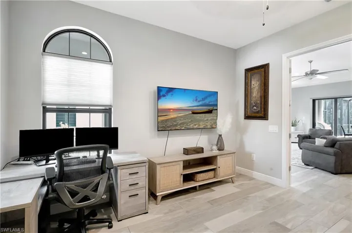 Spacious den/office space adjacent to living room featuring French doors