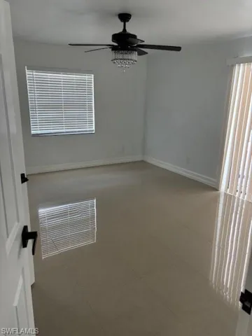 Unfurnished room featuring light tile patterned flooring and ceiling fan