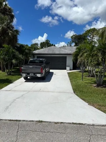 View of home's exterior with a garage, concrete driveway, and a yard