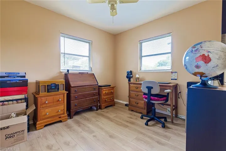Office space featuring plenty of natural light, ceiling fan, and light wood-type flooring