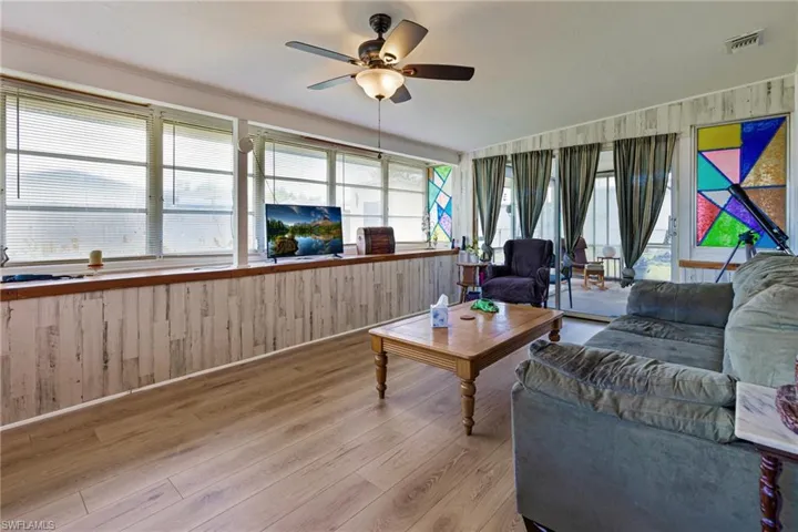 Living room featuring a wealth of natural light, ceiling fan, and light hardwood / wood-style floors