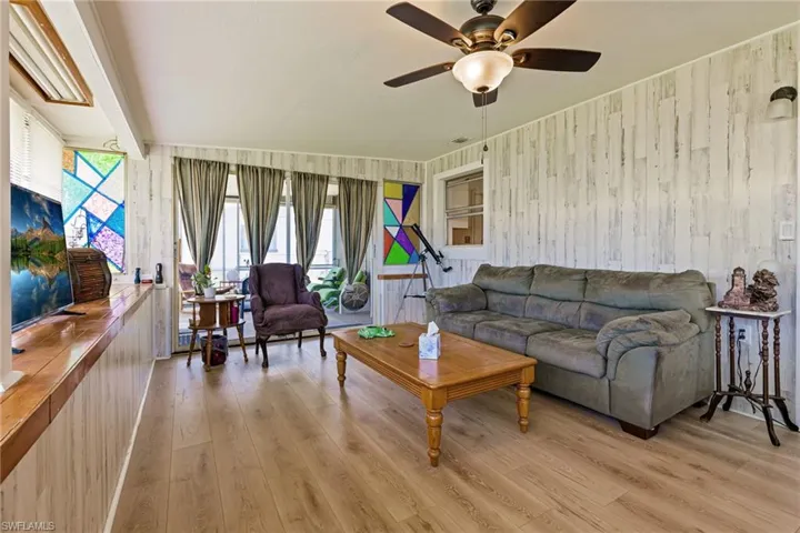 Living room with a healthy amount of sunlight, ceiling fan, and hardwood / wood-style floors