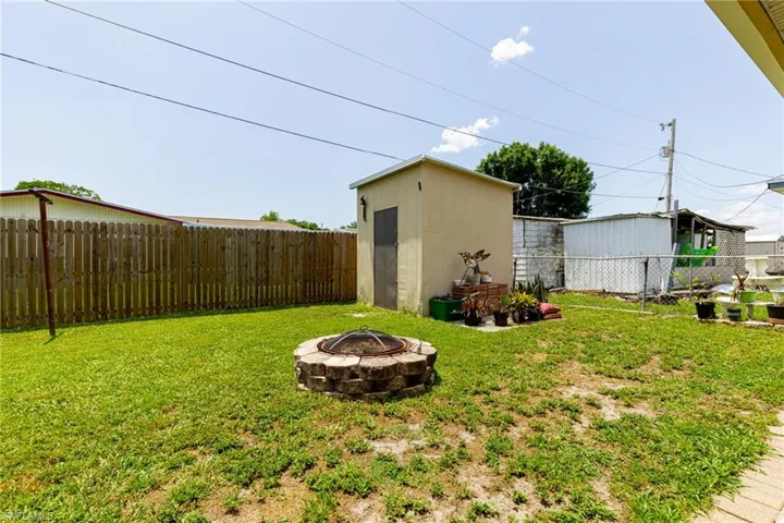 View of yard featuring a fire pit and a shed