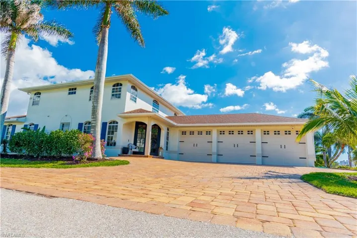 View of front of home featuring a rare 3 car garage and paver circular driveway