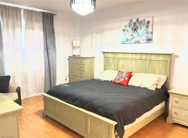 Wood-finish flooring with light wall tones and a ceiling-mounted light fixture