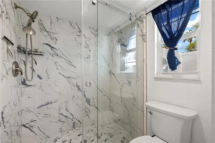 PrimaryBathroom featuring toilet and an enclosed shower