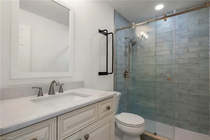 Bathroom with vanity, toilet, and walk in shower