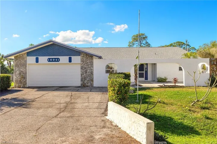 Ranch-style house with a garage and a front lawn