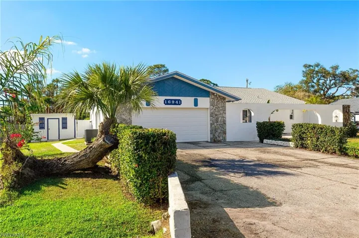 View of front of home with a garage and central air condition unit