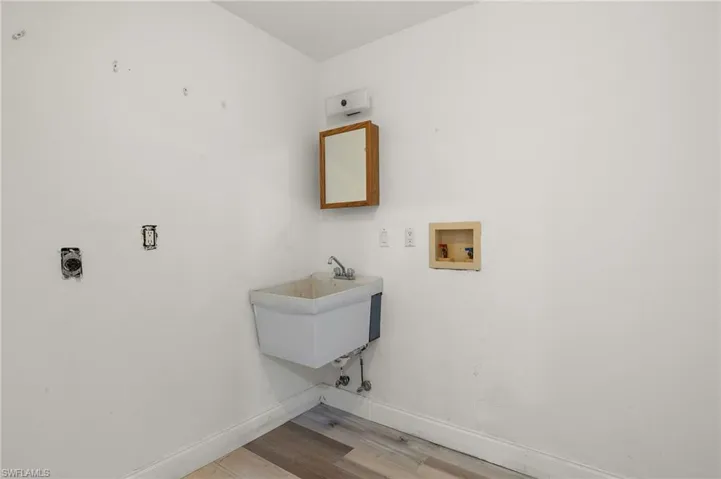 Laundry area with washer hookup, light  wood-style floors, and sink
