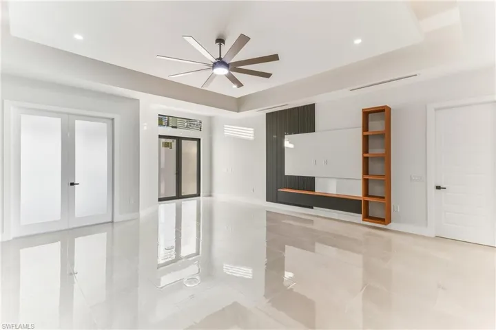 Entry dual Impact resistant storm front doors and dual french private doors to den/ office with Entertainment wall for your TV and Stereo media equipment