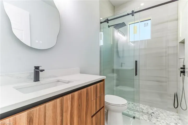 Full bathroom featuring a glass shower stall and vanity