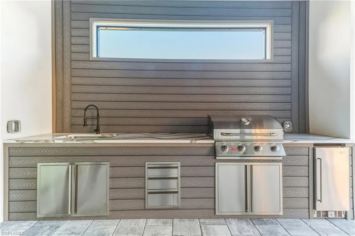 Kitchen featuring stainless steel drink fridge and a sink