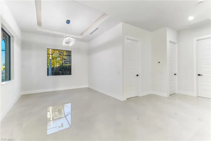 Spare room with a raised ceiling and suspended lighting