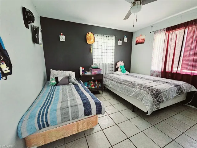 Tiled bedroom with a ceiling fan