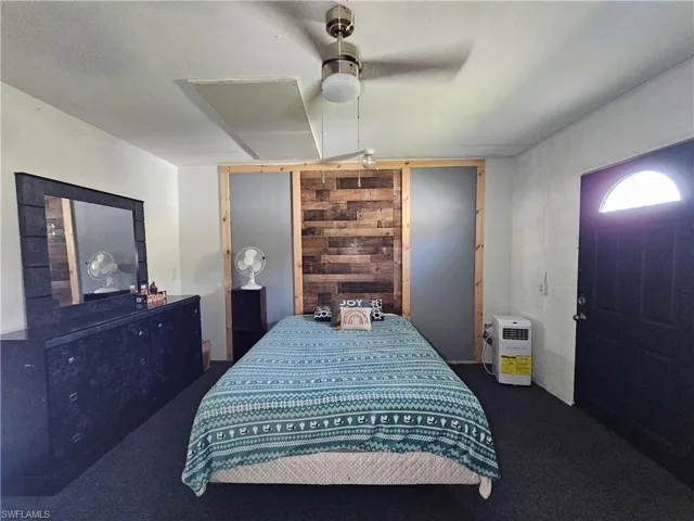 Carpeted bedroom featuring a ceiling fan